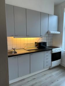 eine Küche mit weißen Schränken und einem Waschbecken in der Unterkunft Concept Exodo Apartments in Oslo