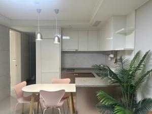 a kitchen with a table and two pink chairs at Landmark Songdo Stay in Incheon