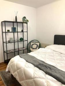 a bedroom with a white bed and a book shelf at Cosy Apartment nearly City Hall Vienna and Subway in Vienna