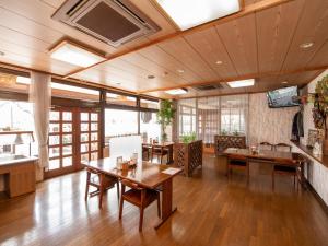 a large room with wooden tables and chairs at Tabist Hotel Sun Plaza Fuefuki Isawa in Fuefuki