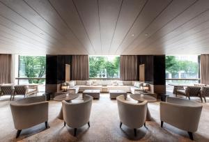 a large room with couches and tables and chairs at The Royal Park Hotel Iconic Kyoto in Kyoto