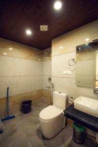 a bathroom with a white toilet and a sink at The Forest Pinnacle & Café, Manali in Manāli