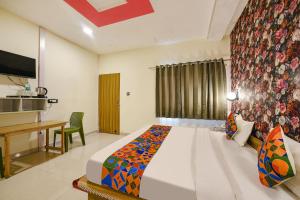 a bedroom with a bed and a table and a desk at FabHotel Sizzling Resort & Adventure in Dhanaulti