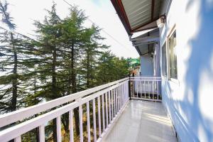 a balcony of a house with a white railing at FabHotel Sizzling Resort & Adventure in Dhanaulti