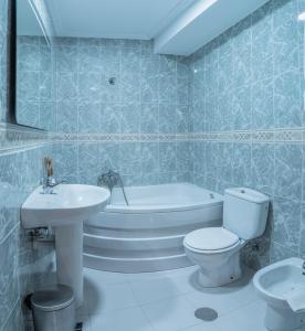 een badkamer met een toilet, een bad en een wastafel bij Hostal Julio Cesar in La Virgen del Camino