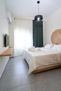 1 dormitorio con cama grande y ventana grande en INOHO Fern Apartment, en Xanthi
