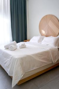 1 dormitorio con 1 cama con toallas en INOHO Fern Apartment, en Xanthi