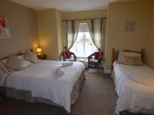 a hotel room with two beds and a window at Parkhouse B&B in Bunratty