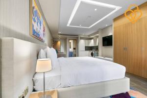 a bedroom with a large white bed and a kitchen at Keysplease Modern Studio Near Beach, Murjan JBR 609 in Dubai