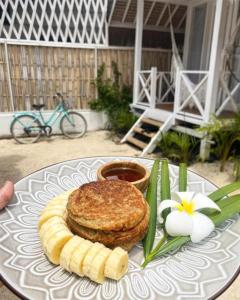 a plate of food with a sandwich and bananas on it at Love Coconut Bungalow in Gili Trawangan