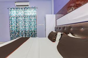 a bedroom with a bed and a curtain at OYO Flagship 81544 Hotel Drip Inn in Lucknow