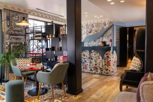 een kamer met een tafel en stoelen en een plank bij Hotel L’Antoine in Parijs