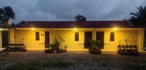 una casa amarilla con luces delante de ella en Tazrah roomstay (1 queen or 2 twin super single room) en Kuala Rompin