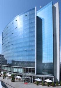 a large glass building with umbrellas in front of it at Holiday Inn Cottbus by IHG in Cottbus +5 photos
