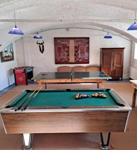 a ping pong table in a room with two tables at Ferienwohnung Ottmanach Josefhof in Pischeldorf
