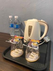a tea kettle and two bottles of water on a tray at The Grand Hotel 2 in Bandar Indah