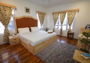 um quarto com uma cama grande e 2 janelas em Moustache Srinagar em Srinagar