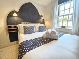 1 dormitorio con 1 cama grande y toallas. en George Hudson Court Apartments, en York