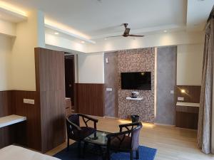 a room with a table and chairs and a tv on a wall at The Awadh Retreat in Lucknow