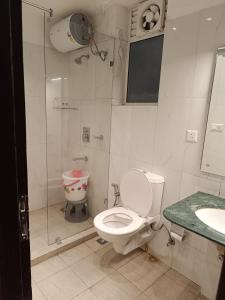 a bathroom with a toilet and a shower and a sink at The Awadh Retreat in Lucknow