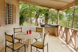 a patio with a table and chairs on a balcony at Waterberry Hill in Hazyview