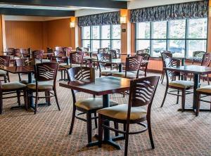 a dining room with tables and chairs and windows at Norwood Inn Statefare Grounds in Columbus