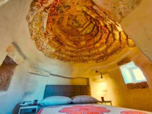 Cette chambre comprend un lit orné d'un tableau au plafond. dans l'établissement Pajara Enka, à Depressa