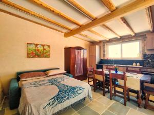 - une chambre avec un lit et une salle à manger avec une table dans l'établissement Pajara Enka, à Depressa