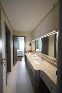 a bathroom with a sink and a large mirror at Obeir Resident Hotel - فندق اوبير السكني in Riyadh