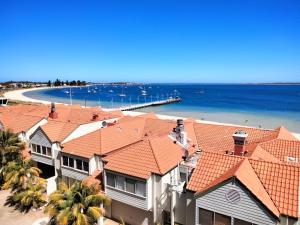 a group of houses with orange roofs and a beach at The Boardwalk Apartment in Rockingham