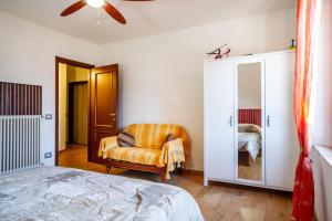 een slaapkamer met een bed en een stoel bij Assiolo in Magliano in Toscana