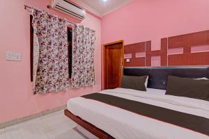 una camera da letto con un grande letto e pareti rosa di OYO Flagship 81544 Hotel Drip Inn a Lucknow