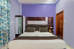 una camera da letto con un grande letto con pareti viola di OYO Flagship 81544 Hotel Drip Inn a Lucknow