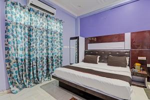 a bedroom with a large bed and a curtain at OYO Flagship 81544 Hotel Drip Inn in Lucknow