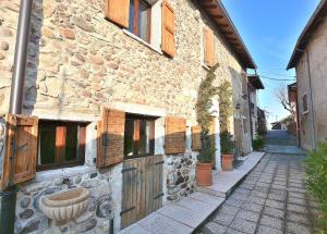 a stone building with a wooden door on a street at Casetta Renzi in Calmasino
