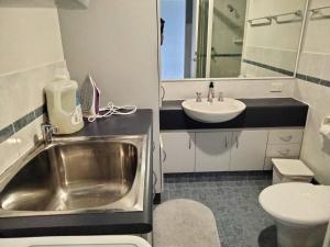 a small bathroom with a sink and a toilet at The Boardwalk Apartment in Rockingham