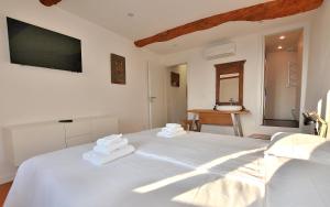 a bedroom with a white bed with towels on it at Casetta Renzi in Calmasino