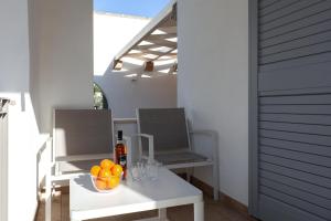 uma mesa com uma taça de laranjas e uma garrafa de vinho em Sunny House Trilo with Pool - Happy Rentals em Sanarica