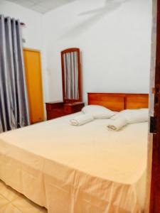 una camera da letto con un grande letto con lenzuola bianche di Royal Princess Holiday Inn a Alutgama
