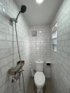 y baño blanco con aseo y ducha. en LaKalena Private Villa Bali, en Ketewel