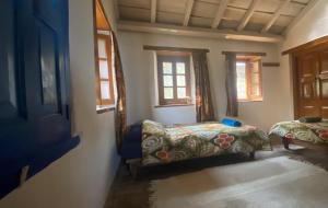 Pokój z 2 łóżkami i 2 oknami w obiekcie Adara Farmstay w mieście Pauri