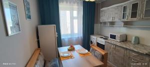 阿斯克卡明諾戈斯克的住宿－Lux Home на берегу Ульбы，一间带桌子和冰箱的小厨房