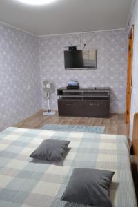 a bedroom with a bed with a tv on the wall at Квартира на Назарбаева in Kokshetau