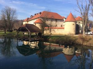 a building with a reflection in a body of water at Apartment Prešeren in Smarjeske Toplice