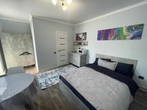 a bedroom with a bed and a table in it at Гостевой дом Инжу in Almaty