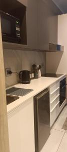 a kitchen with a counter top with a microwave at Menlyn Maine Trilogy Apartment 1518 in Pretoria