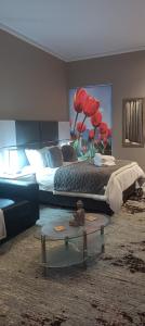 Menlyn Maine Trilogy Apartment 1518 في بريتوريا: غرفة نوم بسرير وطاولة في غرفة