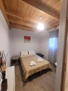 1 dormitorio con 1 cama con 2 toallas en Lefkada Center Apartments, en Lefkada