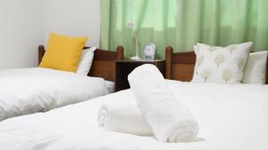 - 2 lits avec des draps et des oreillers blancs dans une chambre dans l'établissement Casa Hakuba, à Hakuba