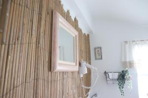un espejo en una pared junto a un baño en Borboleta Guest House, en Figueira de Castelo Rodrigo